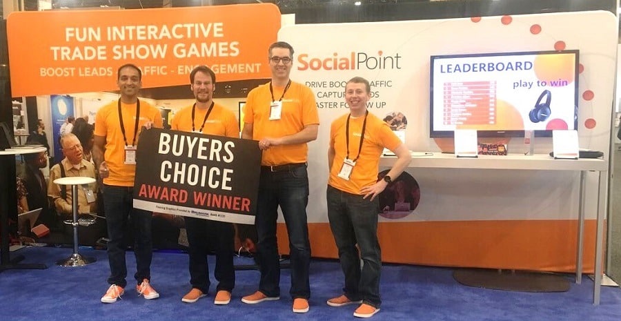 SocialPoint team at EXHIBITORLIVE 2018 celebrates winning Buyers Choice Award next to trade show trivia game leaderboard
